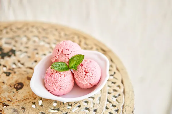 Παγωτό φράουλα με φύλλα δυόσμου. τρεις μπάλες σε ένα λευκό μπολ σε ένα vintage τραπέζι. σορμπέ — Φωτογραφία Αρχείου