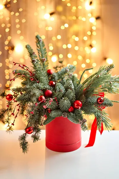 Weihnachtliches Arrangement mit norwegischer Kiefer Nobilis und weihnachtlichem Dekor in einem Metallbecher. Garland Bokeh auf dem Hintergrund. Weihnachtsliebe. Dunkler Holztisch mit Schnee bestreut — Stockfoto