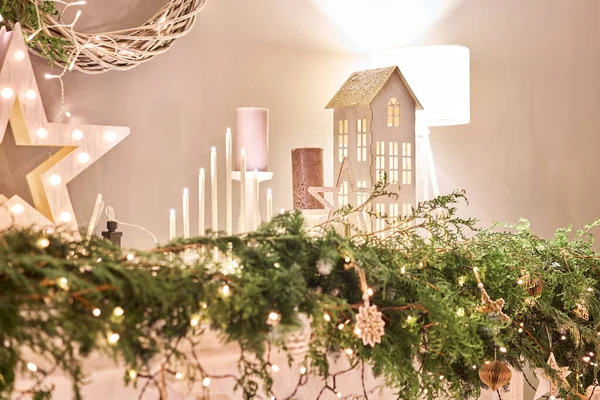 Díszített kandalló. Karácsonyfa. Közelkép egy kis ház, kúp, koszorú, és más karácsonyfa játékok. fény a koszorúból — Stock Fotó