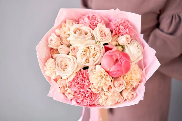 Mooi boeket bloemen in de hand van de vrouw. Bloemenwinkel concept. Mooi vers gesneden boeket. Bloemen levering — Stockfoto