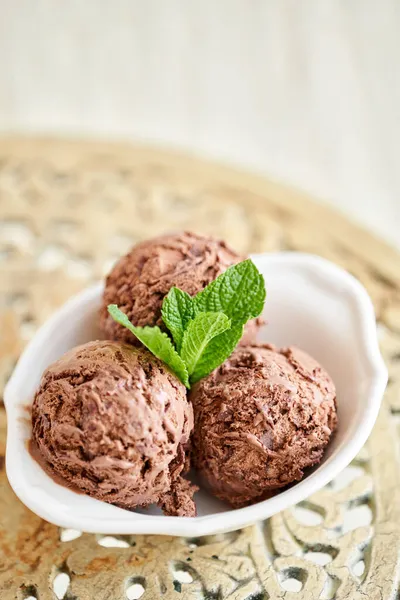 Cokelat es krim dengan daun mint. tiga bola dalam mangkuk putih di meja vintage. — Stok Foto