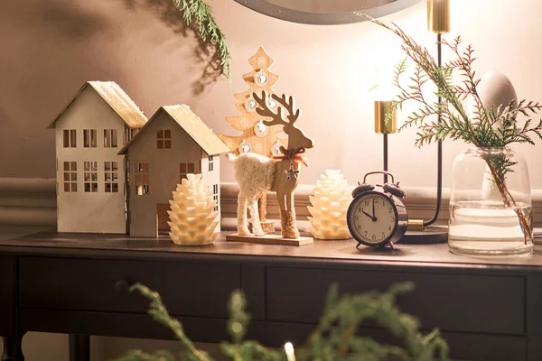 Gedecoreerde tafel in het interieur van Kerstmis. Kerstboom. Close-up van een klein huis, kegels, slinger, en andere kerstboom speelgoed. licht van de slingers — Stockfoto