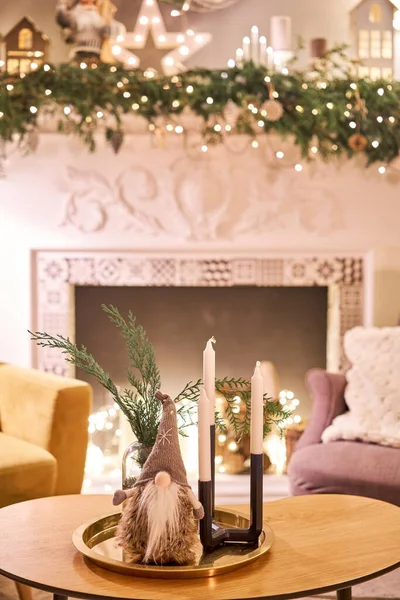 Mesa decorada en el interior de Navidad. Árbol de Navidad. Acercamiento de una pequeña casa, Conos, guirnalda, y otros juguetes del árbol de Navidad. luz de las guirnaldas — Foto de Stock