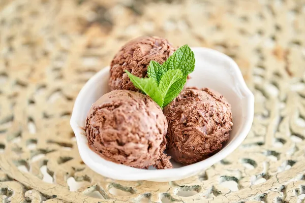 Cokelat es krim dengan daun mint. tiga bola dalam mangkuk putih di meja vintage. — Stok Foto