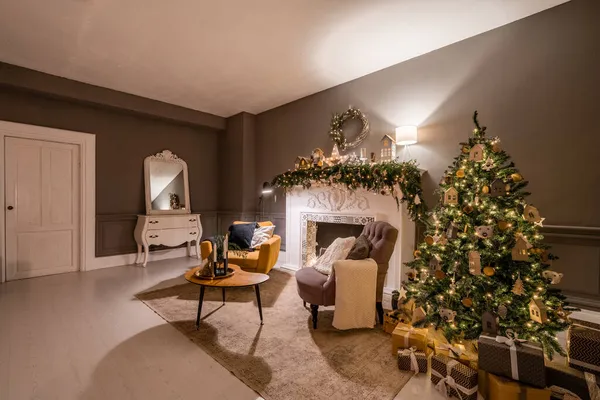 Apartamentos clásicos con árbol de Navidad decorado y regalos. Noche de Navidad a la luz de velas y guirnaldas. Vivir con chimenea y estuco. — Foto de Stock