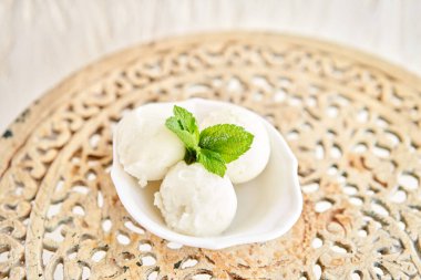 Naneli Linon dondurması. Eski bir masada beyaz bir kasede üç top. şerbet