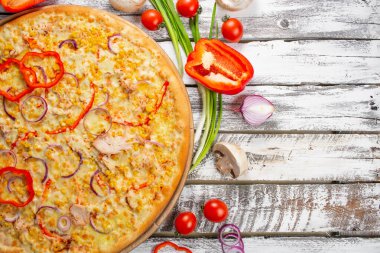 Tavuk, kırmızı biber ve mısırlı pizza. İtalyan mutfağı ve yemek pişirme konsepti. Napoli Pizzacısı 'nda pizza dilimleyen bir şef..