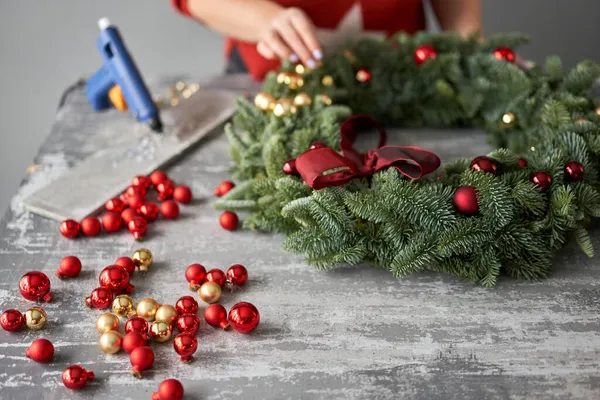 Vrouw maken kerstkrans van takken van dennen voor vakantie. Masterclass over het maken van decoratieve ornamenten. Kerstdecor met eigen handen. Het nieuwjaarsfeest. Bloemenwinkel — Stockfoto
