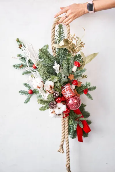 Χριστουγεννιάτικο δώρο. Όμορφη εορταστική πινελιά φρέσκου έλατου στον γκρίζο τοίχο. Χριστουγεννιάτικη διάθεση. — Φωτογραφία Αρχείου
