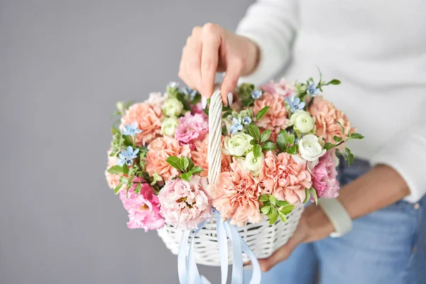 Układanie kwiatów w wiklinowym koszu. Piękny bukiet mieszanych kwiatów w ręce kobiety. Ładny, świeży bukiet. Mały kwiaciarnia i kwiaty dostawy. — Zdjęcie stockowe