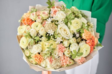 Beautiful large bouquet of mixed flowers in woman hand. Handsome fresh bouquet. Small flower shop and Flowers delivery.