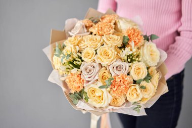 Beautiful large bouquet of mixed flowers without packaging. Handsome fresh bouquet in woman hand. Small flower shop and Flowers delivery.