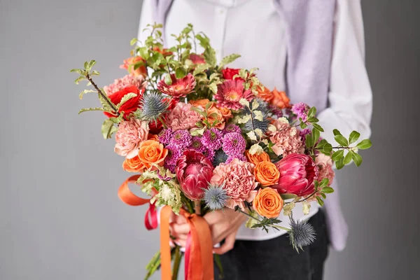 Beautiful large bouquet of mixed flowers without packaging. Handsome fresh bouquet in woman hand. Small flower shop and Flowers delivery. — 스톡 사진