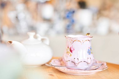 teapot and cup. A magnificent porcelain tea set with a fragrant tea. Green and black tea concept. Side view