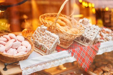 A bakery showcase in a European city for Christmas. Gingerbread house, pretzel, apple crumble, buns. Bread on Christmas and New year.