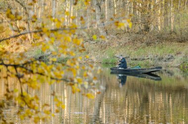 Begec, Sırbistan - 30 Ekim. 2021: Novi Sad yakınlarındaki yapay bir gölde kayıkta spor balıkçısı.