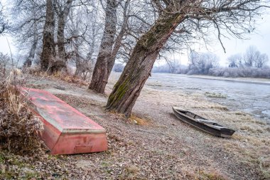 Tahta bir balıkçı teknesi Tuna Nehri 'nin kıyısında donmuş sularda sürüklendi..