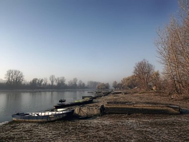 Sırbistan 'ın Novi Sad kenti yakınlarındaki Tuna Nehri' nin kolunda unutulmuş bir balıkçı teknesi.
