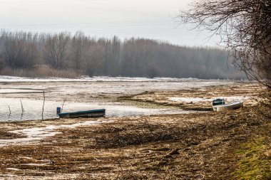 Tahta tekneler gölün donmuş sularında unutuldu..