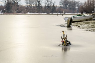 Tahta tekneler gölün donmuş sularında unutuldu..