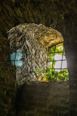 Petrovaradin Kalesi 'nin duvarında metal parmaklıklar olan eski pencere..