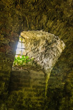 Petrovaradin Kalesi 'nin duvarında metal parmaklıklar olan eski pencere..