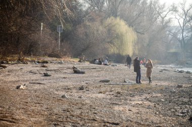 Novi Sad, Sırbistan. Mart - 16. 2022 yılı. Bahar güneşli bir günde, Tuna kıyılarında yürüyen insanlar..