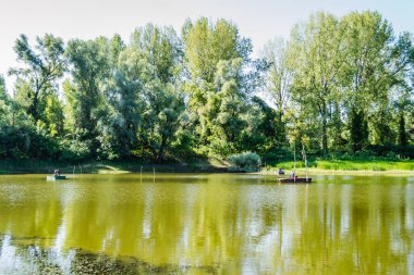 Novi Sad, Sırbistan - 17 Ağustos 2019: Spor balıkçıları Novi Sad yakınlarındaki bir teknede gölün suyunun keyfini çıkarıyorlar.