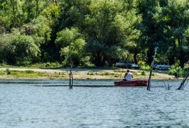 Novi Sad, Sırbistan - 17 Ağustos 2019: Spor balıkçıları Novi Sad yakınlarındaki bir teknede gölün suyunun keyfini çıkarıyorlar.