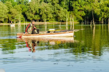 Novi Sad, Sırbistan - 17 Ağustos. 2019: Balıkçılar tahta tekneleriyle sahilin diğer tarafına geçiyor.