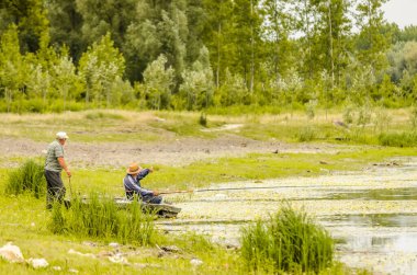 İki balıkçı oltayla balık tutmayı sever..