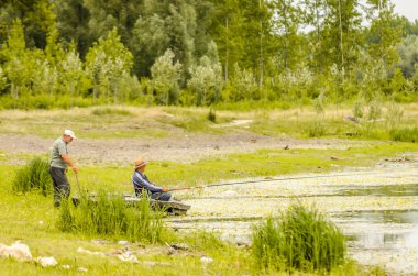 İki balıkçı oltayla balık tutmayı sever..