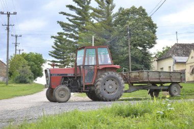 Evin önünde karavanı olan eski bir traktör..