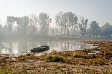 Tahta balıkçı teknesi kışın Tuna nehrinin kıyısına demir attı..
