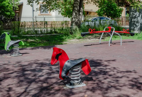 Novi Sad, Sırbistan. Nisan - 26. 2022 yılı. Güneşli bir bahar günü erken saatlerde oynanacak slayt ve oyunlar da dahil olmak üzere çeşitli oyuncakları olan renkli oyun alanı ekipmanları..