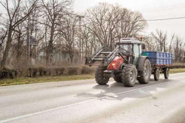 Novi Sad, Sırbistan - Mart 05. 2021: Kırmızı bir tarım traktörü otoyolda sürüyor.