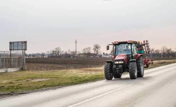 Novi Sad, Sırbistan - Mart 05. 2021: Kırmızı bir tarım traktörü otoyolda sürüyor.