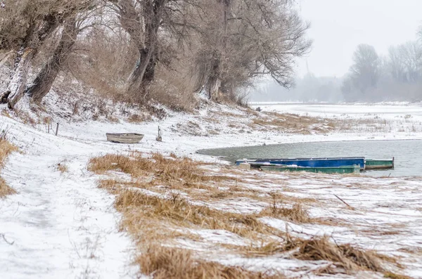Tuna Nehri 'nin kıyısında donmuş suda demirli ahşap bir balıkçı teknesi..