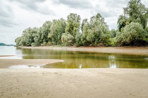 The sandy bank of the Danube River near the city of Novi Sad. Panorama banks of the river Danube near the Petrovaradin. One of the city's beaches - Oficirac in Novi Sad.