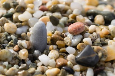 Pebbles on the beach in the small tourist town of Pefkochori, Greece in the late afternoon.