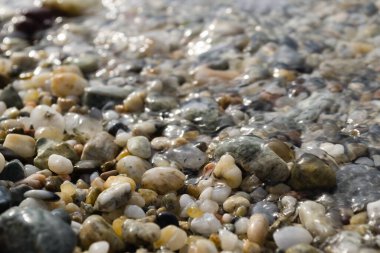 Yunanistan 'ın Pefkochori kentindeki küçük turist kasabasında öğleden sonra kumsalda çakıl taşları.