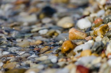 Yunanistan 'ın Pefkochori kentindeki küçük turist kasabasında öğleden sonra kumsalda çakıl taşları.