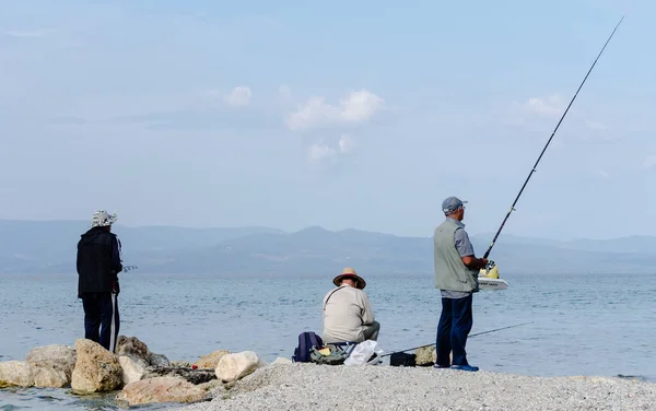 Pefkochori, Greece - May 30, 2016: Fishermen engaged in recreational fishing, on the shores of Pefkochori in Greece