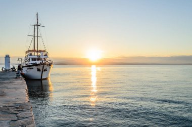 Anchored tourist boat by the waterfront in Pefkochori, Greece. Anchored tourist boat in the morning hours, tied to the waterfront in Pefkochori, Greece.