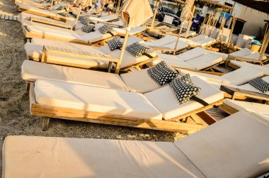 Şemsiyeli sahil manzarası ve şemsiyeli sahilin manzarası ve küçük Pefkochori kasabasında güneşlenmeler. Sabahları küçük Pefkochori kasabasında şezlonglar..