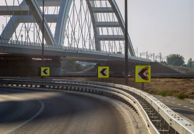 Novi Sad, Sırbistan. Temmuz - 25. 2022 yılı. Petrovaradin tarafından Novi Sad kentindeki Tuna Nehri üzerindeki Zezelj Köprüsü. Petrovaradin tarafından Novi Sad 'da bulunan Eelev Köprüsü' nün altındaki yol kenarındaki trafik işaretlerinin manzarası