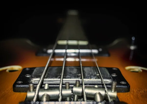 A look at the acoustic bass guitar. View down the neck of a four string bass guitar.