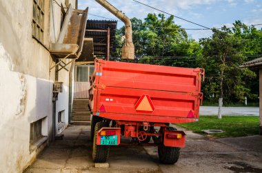 Srbobran is a town in Serbia. Novi Sad, Serbia - Agricultural tractor trailer next to the old mill building in Srbobran, Vojvodina - Serbia.