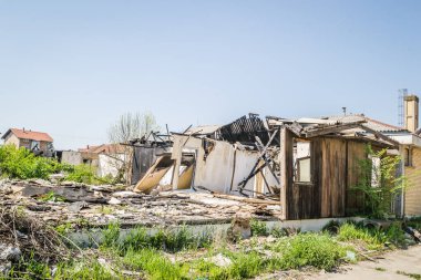 The remains of the burnt house. Ruined and collapsed house burnt and damaged in the fire with remains of the wooden reinforcement poles of roof selective focus. Burned house