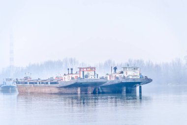 Tankers on the Danube River during the winter period. Anchored tankers on the Danube River in winter.